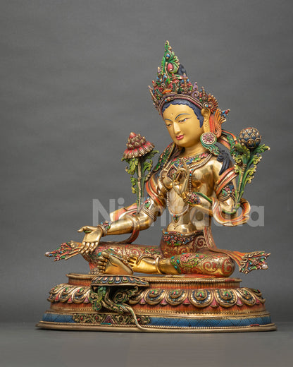 Green Tara copper statue with gold-gilded body and lowered Varada mudra hand, angled side view