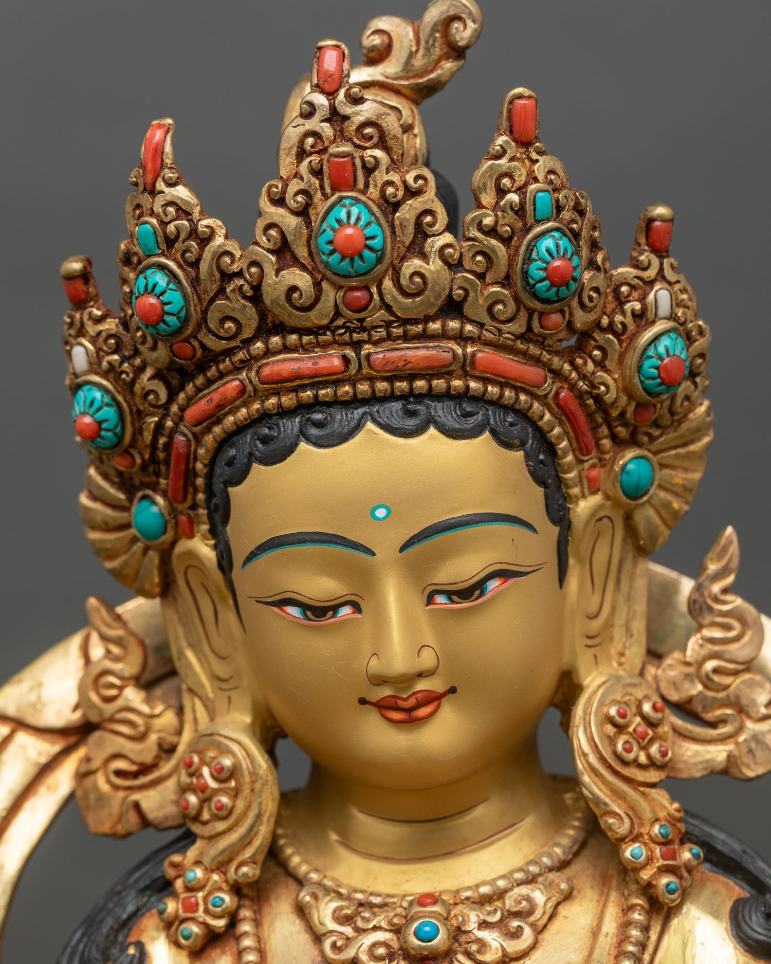 Green Tara face close up with calm gold painted expression and crown details