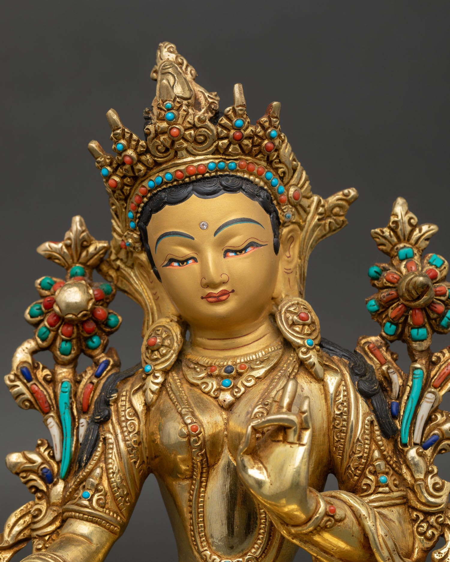 Green Tara face close up gold painted serene expression Himalayan craftsmanship detailed eyes jewelry sacred Buddhist goddess sculpture