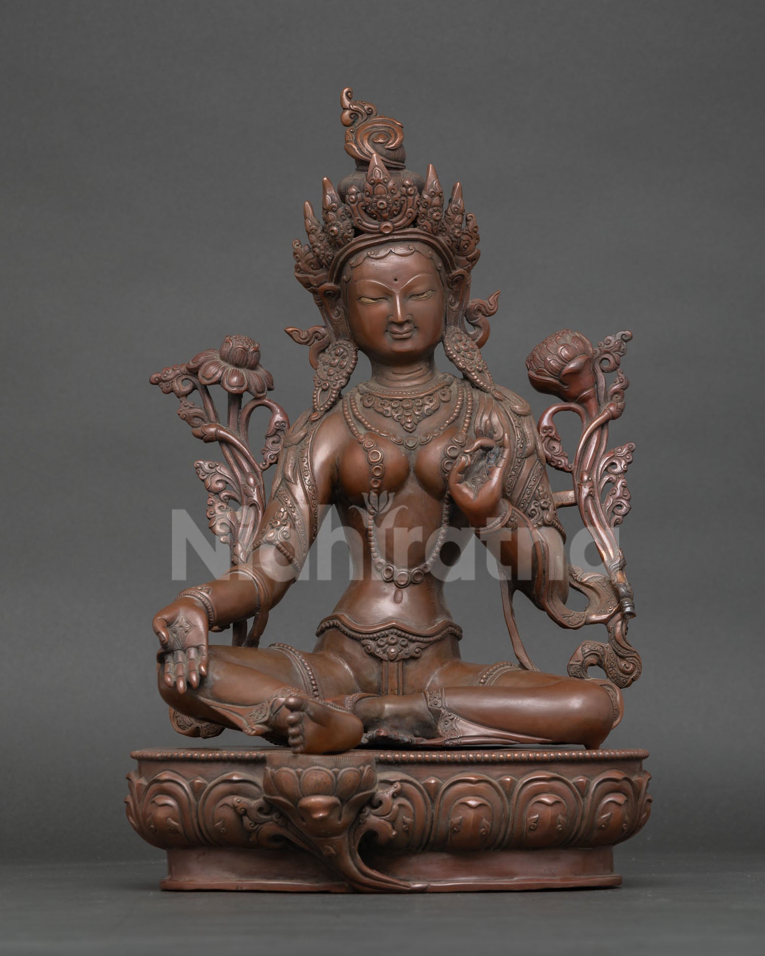 Green Tara holding utpala lotus in Varada Mudra seated on lotus throne copper sculpture.
