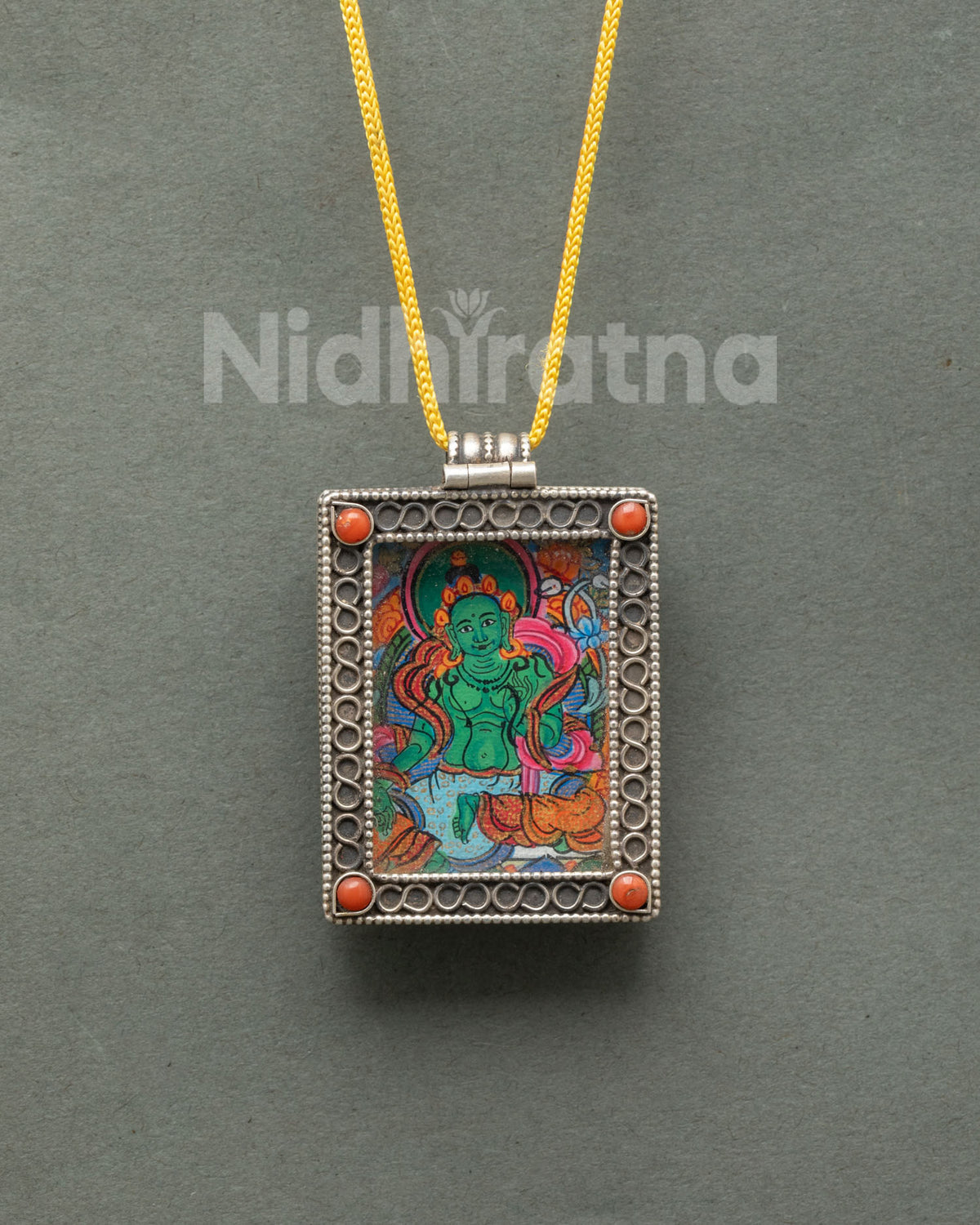Green Tara locket handcrafted from pure silver with intricate filigree patterns and semi-precious coral stones by a Newari artist in Patan Nepal.
