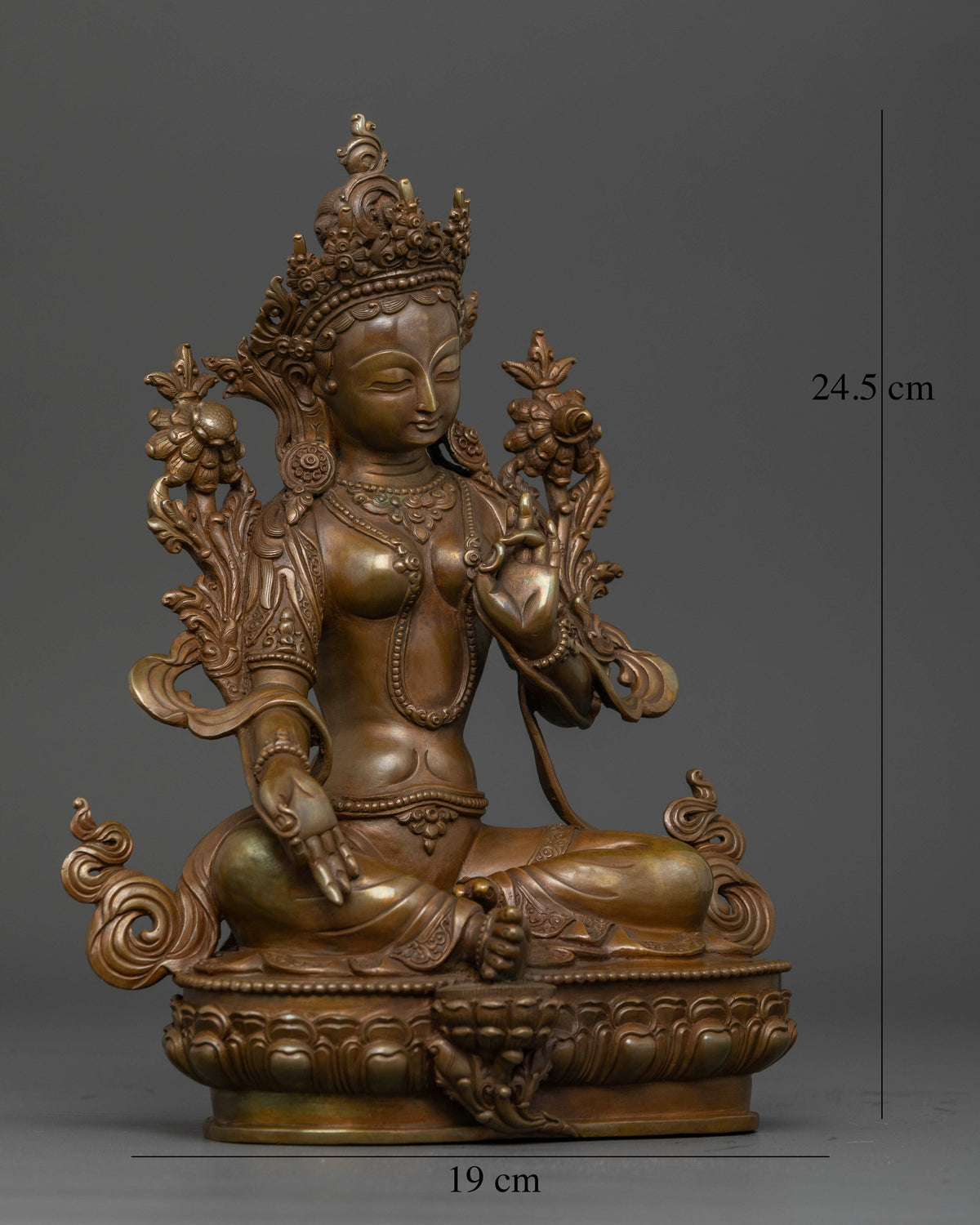 Green Tara seated gracefully on a carved lotus pedestal, holding an utpala lotus.