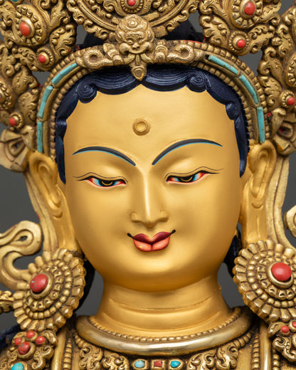 Green Tara serene face detail gold painted features Nepal Buddhist statue closeup