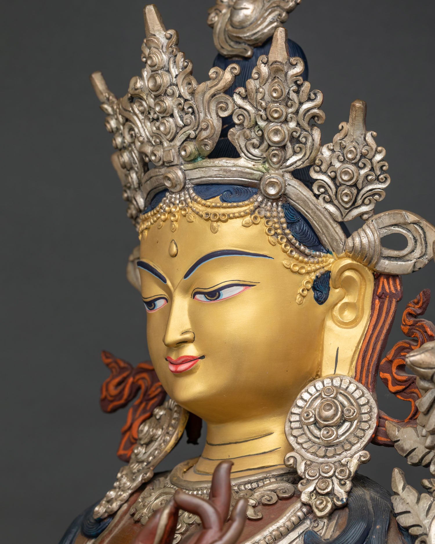 Green Tara side profile face—gold-painted Buddhist statue with jeweled crown, Nepal artisans