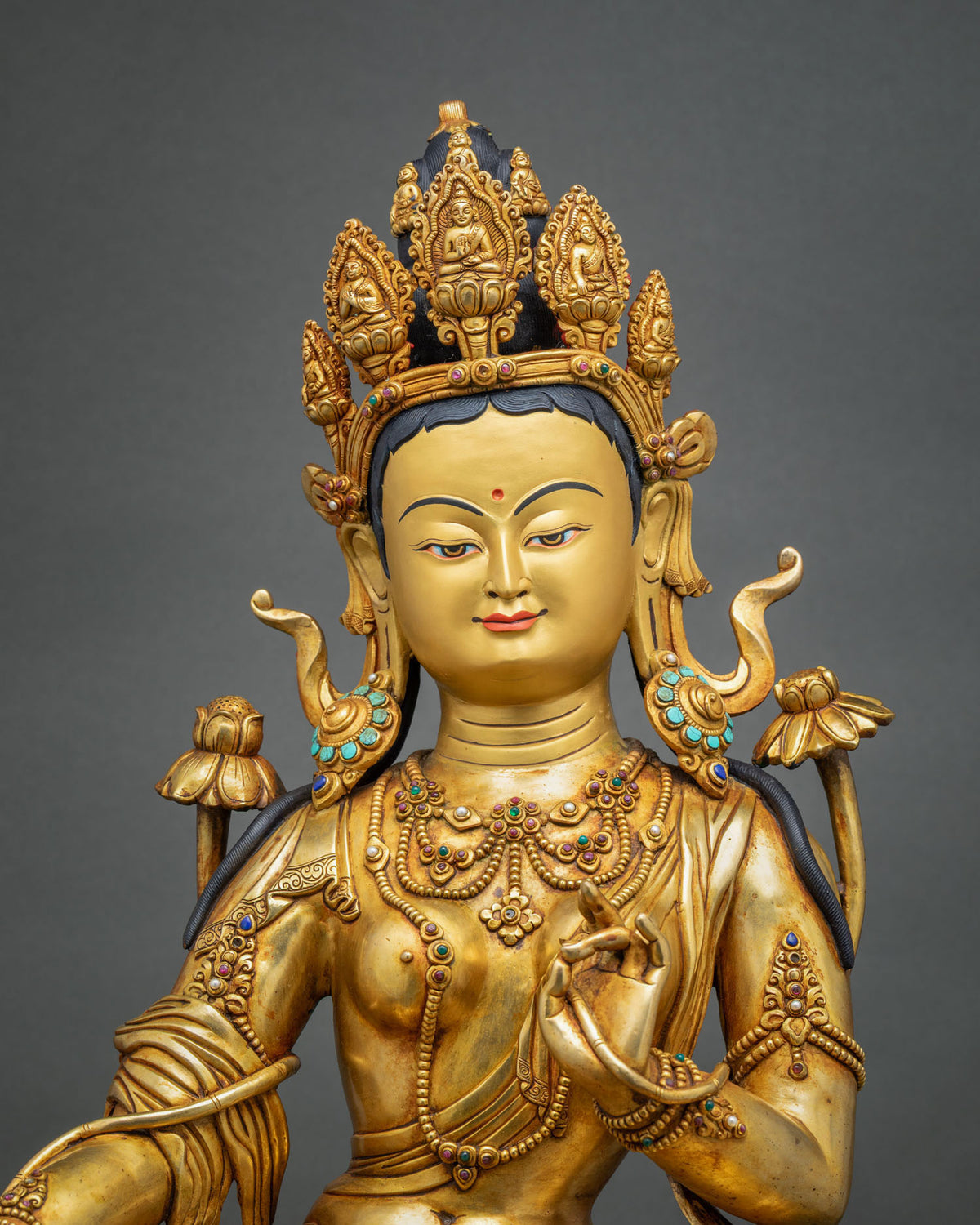 Green Tara statue close-up of face, five-point crown and gemstone jewelry, handcrafted in Nepal