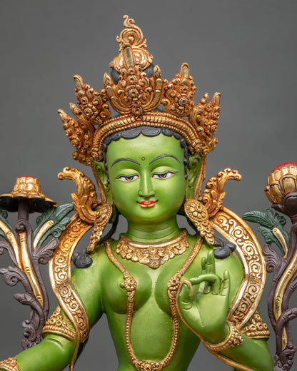 Green Tara statue close up showing ornate jewel crown and serene face.