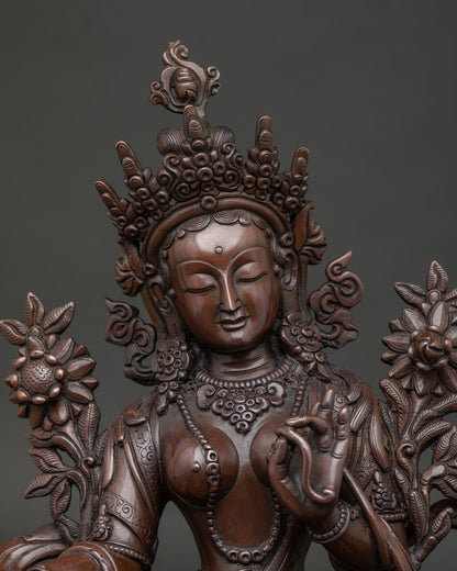 Green Tara Statue close up with jeweled crown and hand carved silk garment.