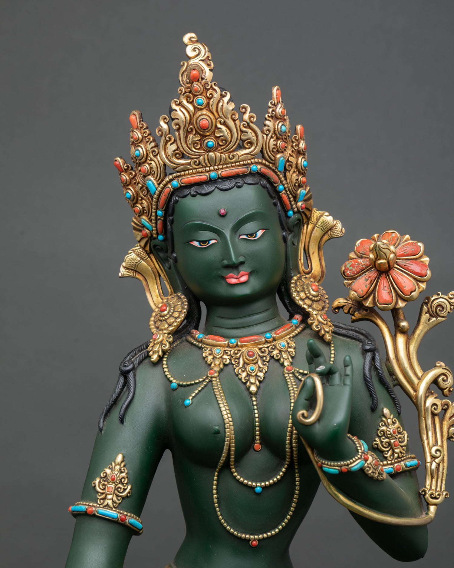 Green Tara Statue displaying Varada Mudra, holding blooming utpala lotus, symbol of spiritual awakening