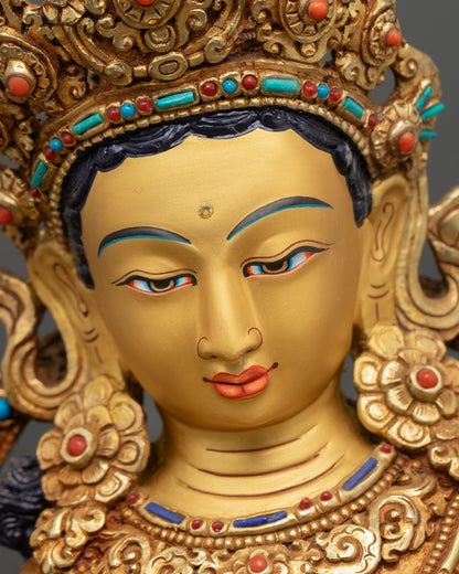 Green Tara Statue face close up serene expression gold painted face