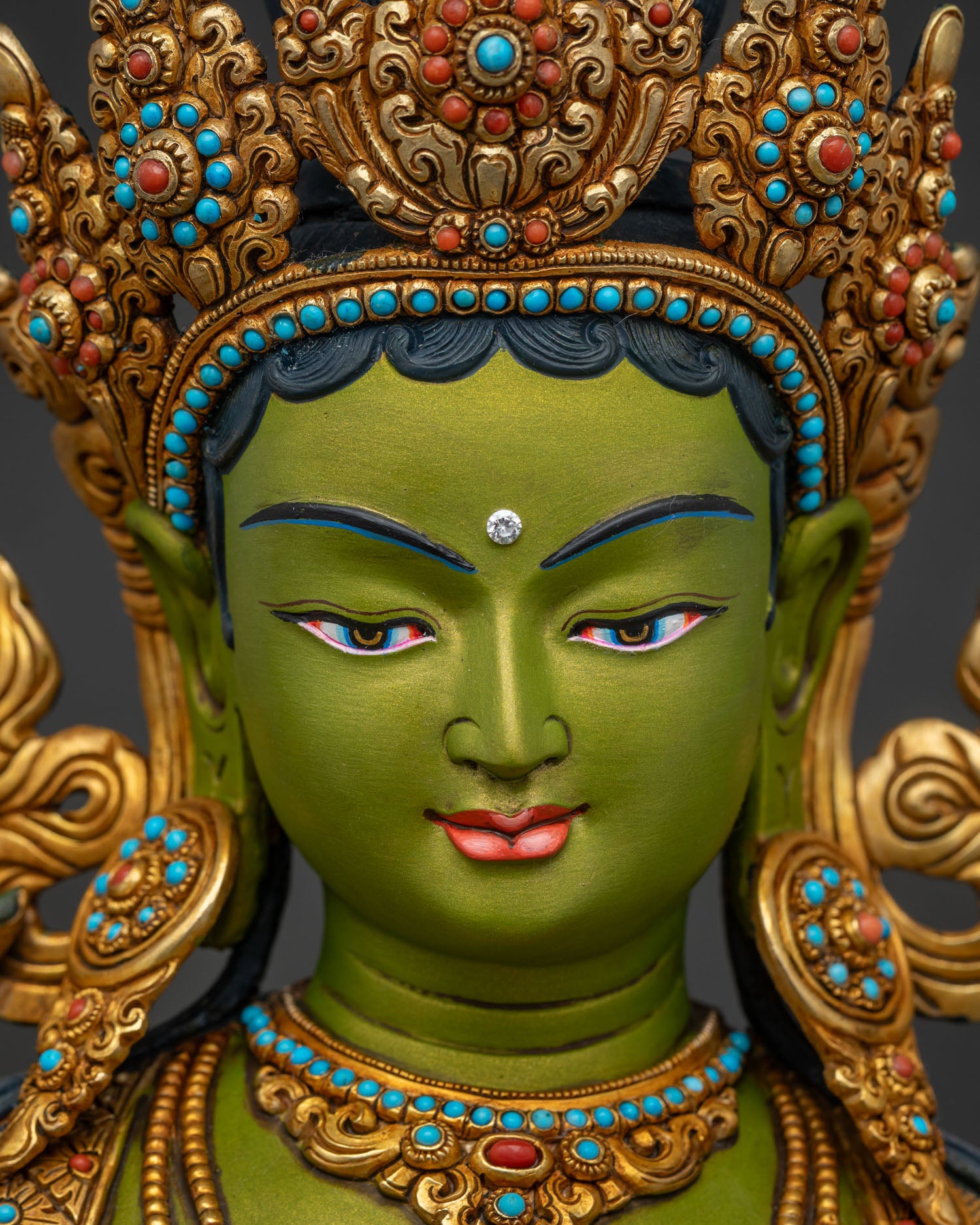 Green Tara statue face close-up – serene hand-painted Buddhist deity expression
