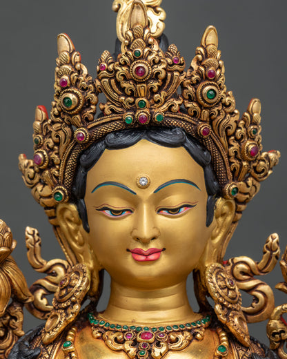 Green Tara statue face close up with serene expression and delicately painted features