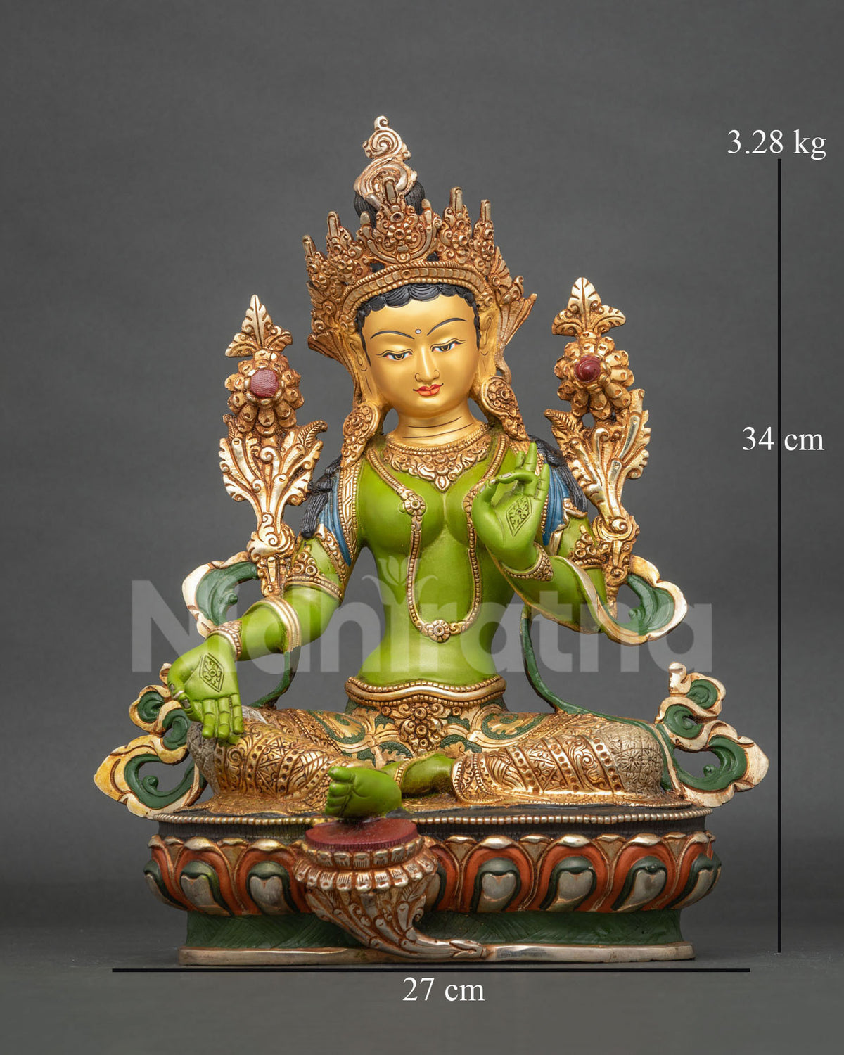 Green Tara statue on a hand carved lotus pedestal with floral patterned silk garment.