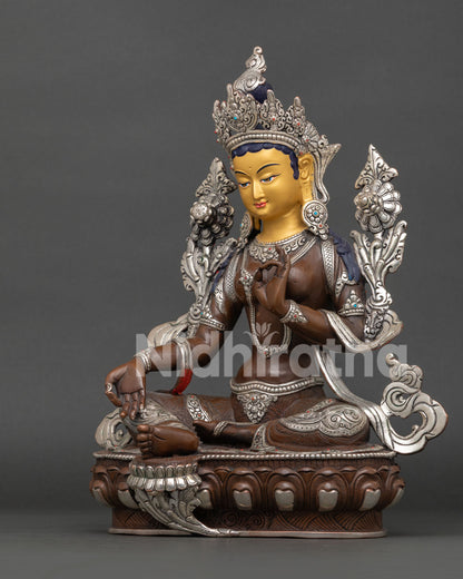 Green Tara statue handcrafted by Newari artisan from Patan Nepal with oxidized silver plated copper finish and gold painted face