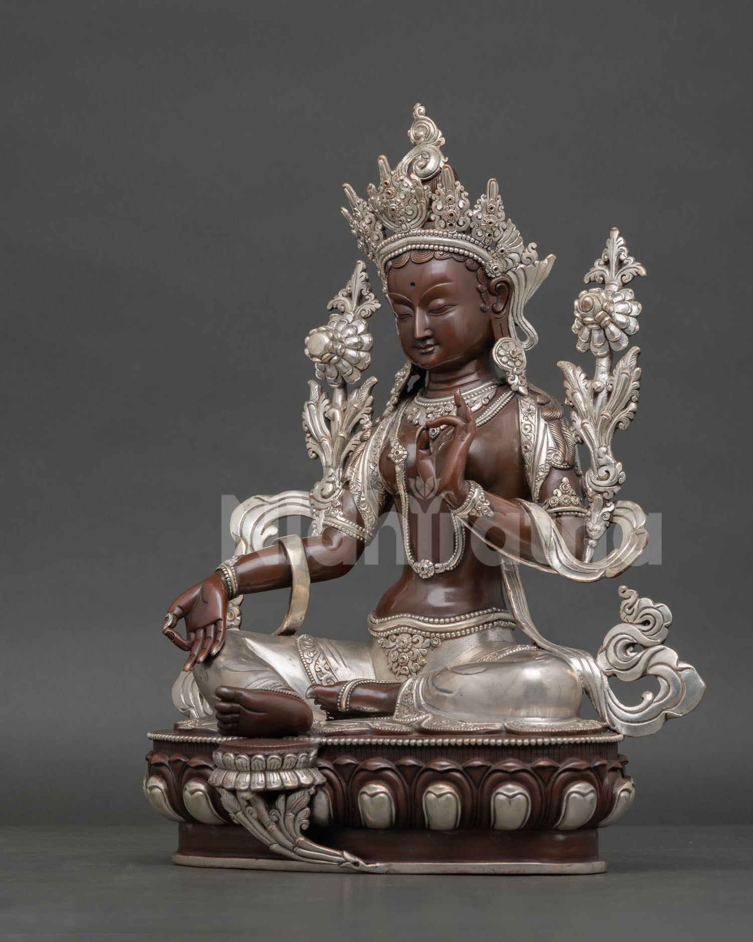 Green Tara statue handcrafted in Nepal with oxidized silver-plated finish, seated on a lotus throne in lalita sana posture.