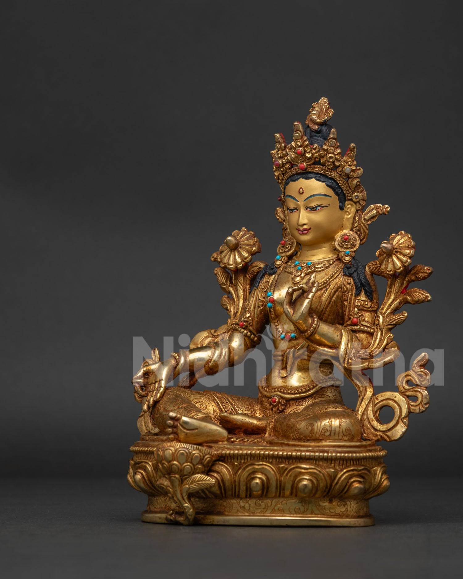 Green Tara statue in graceful posture with hand carved floral garment.