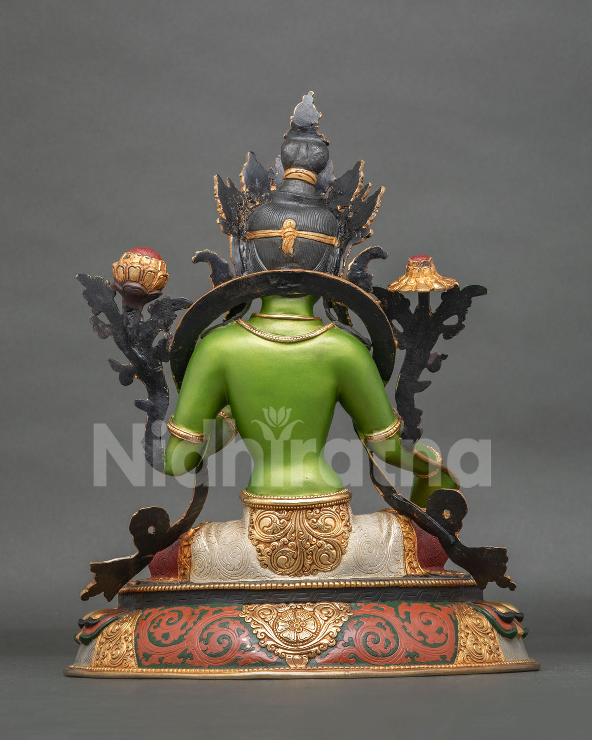 Green Tara statue with intricate three dimensional carving and colorful lotus pedestal.
