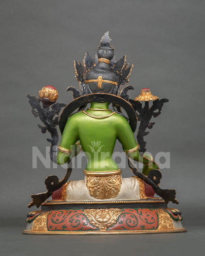 Green Tara statue with intricate three dimensional carving and colorful lotus pedestal.