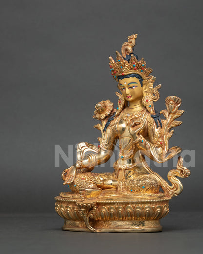 Green Tara statue jeweled crown lotus blossoms generosity gesture.