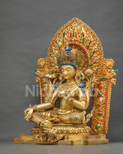 Green Tara statue right side view seated in royal ease posture on lotus base, gold fire-gilded copper