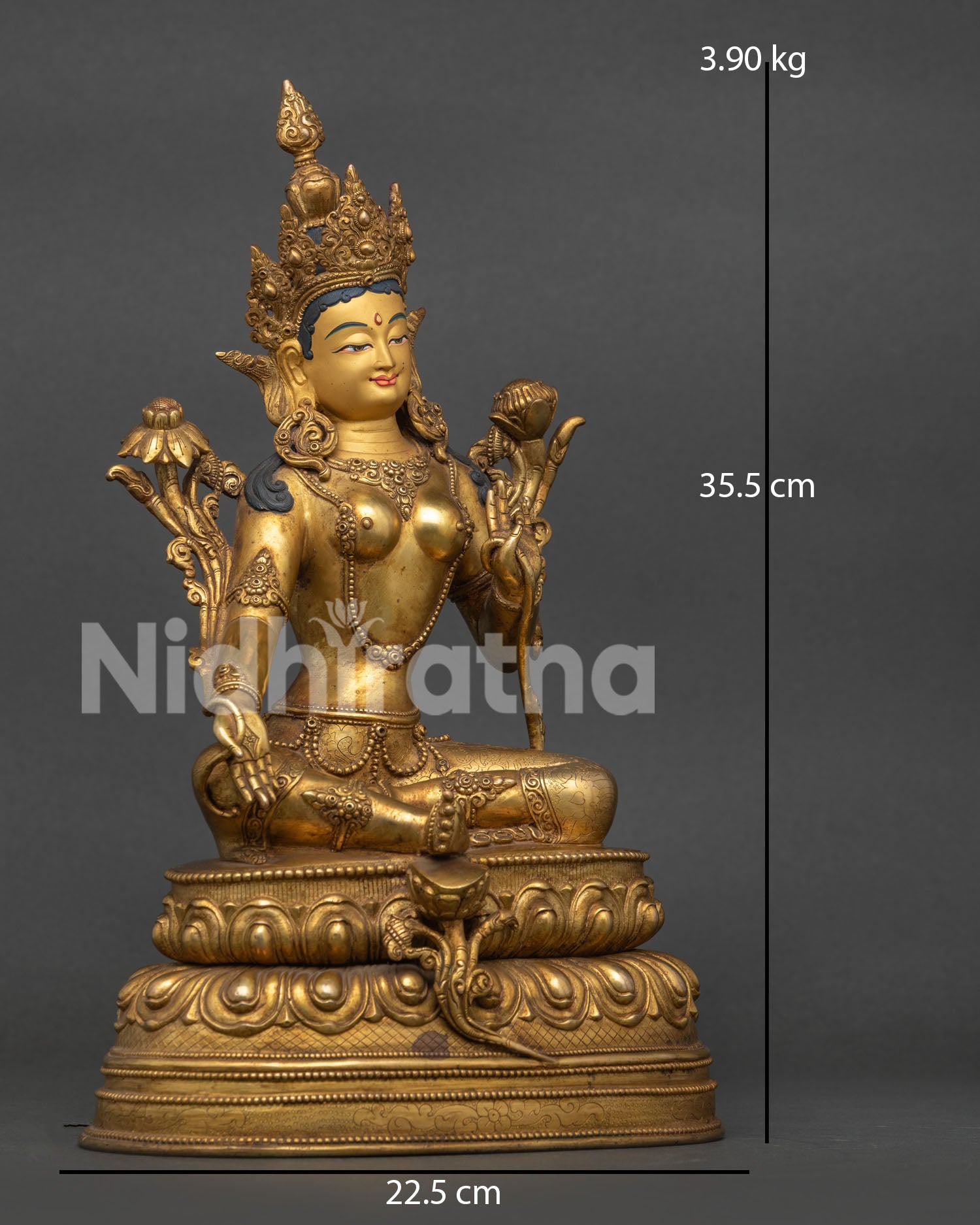 Green tara statue showing varada mudra and blooming utpala flower.