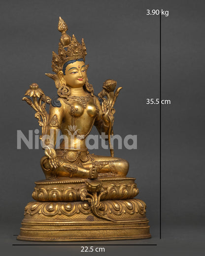 Green tara statue showing varada mudra and blooming utpala flower.