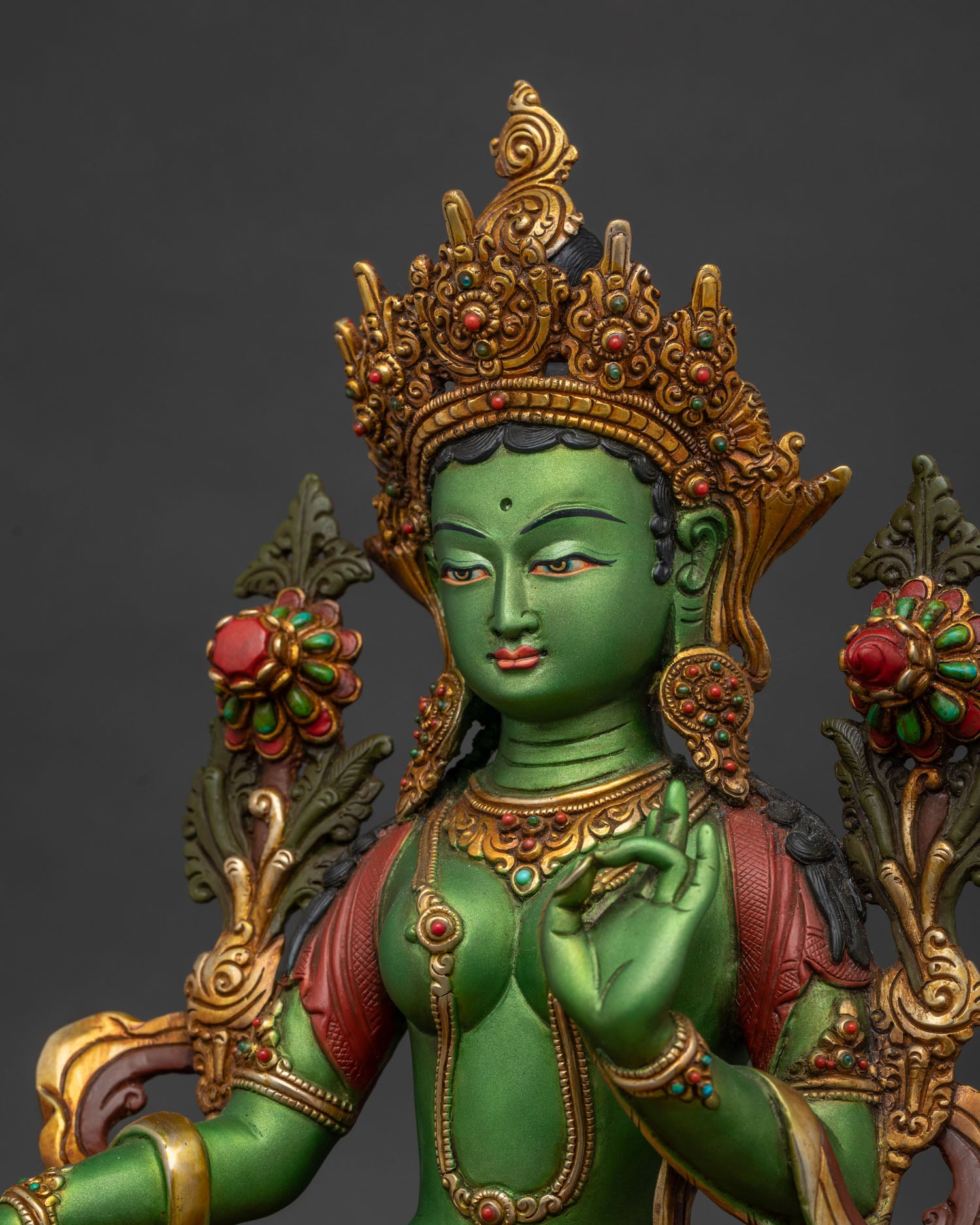 Green Tara statue side close-up, detailed gold gilding and repoussé work
