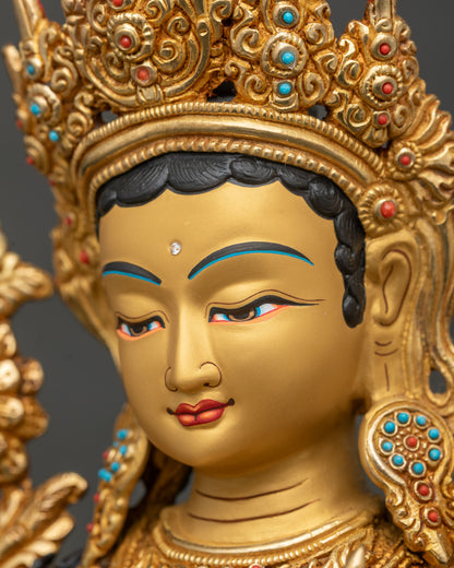 Green Tara statue side face close up jewel crown gold gilded details.