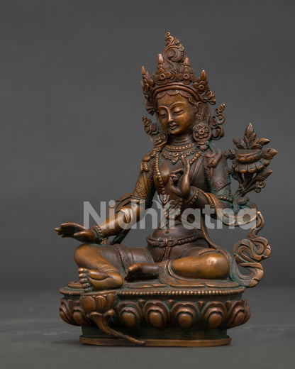 Green Tara statue side view showing flowing robe blooming lotus and ornate pedestal.