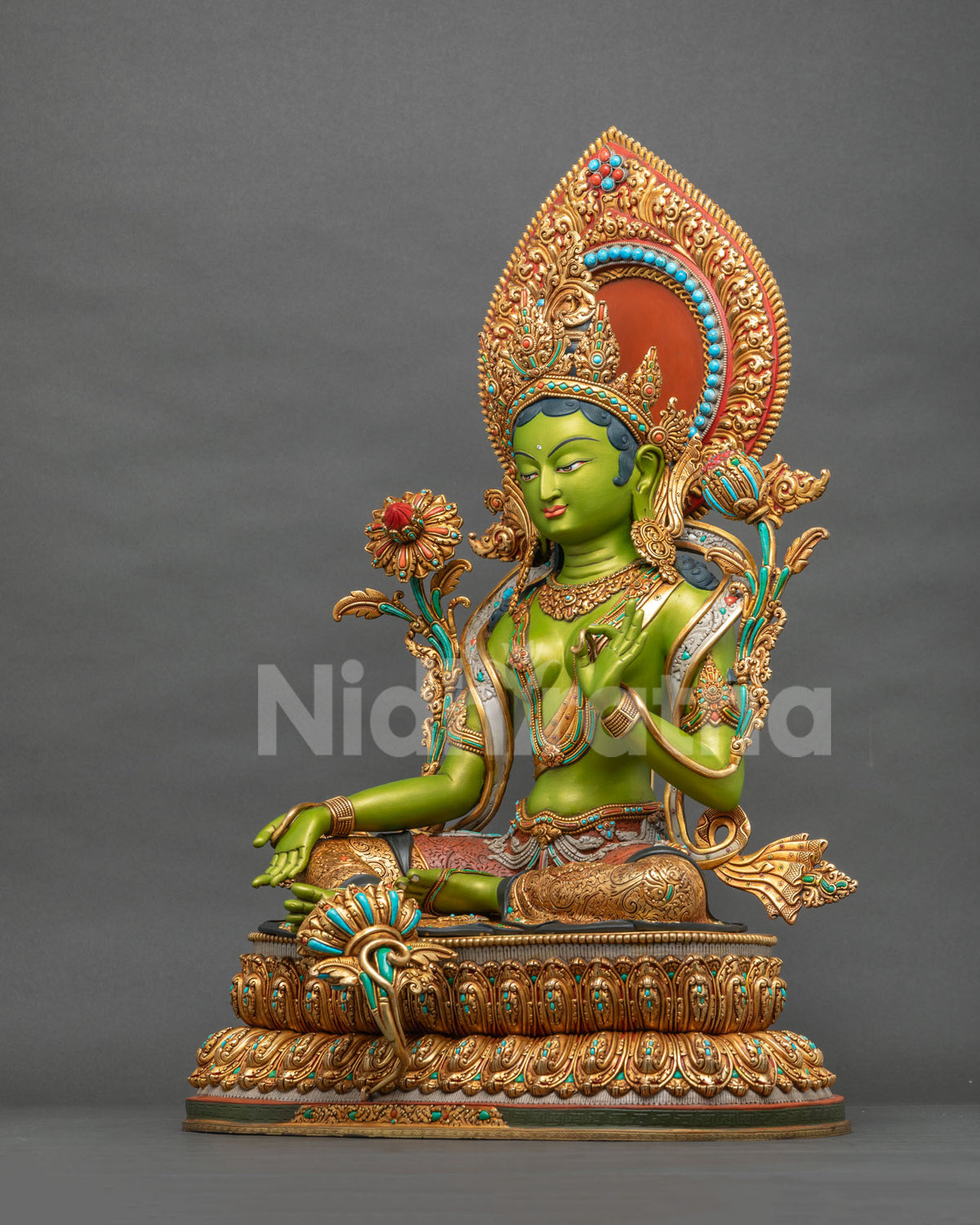Green Tara statue side view showing Varada mudra and gold fire-gilded copper lotus base