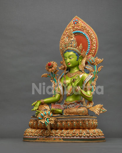 Green Tara statue side view showing Varada mudra and gold fire-gilded copper lotus base