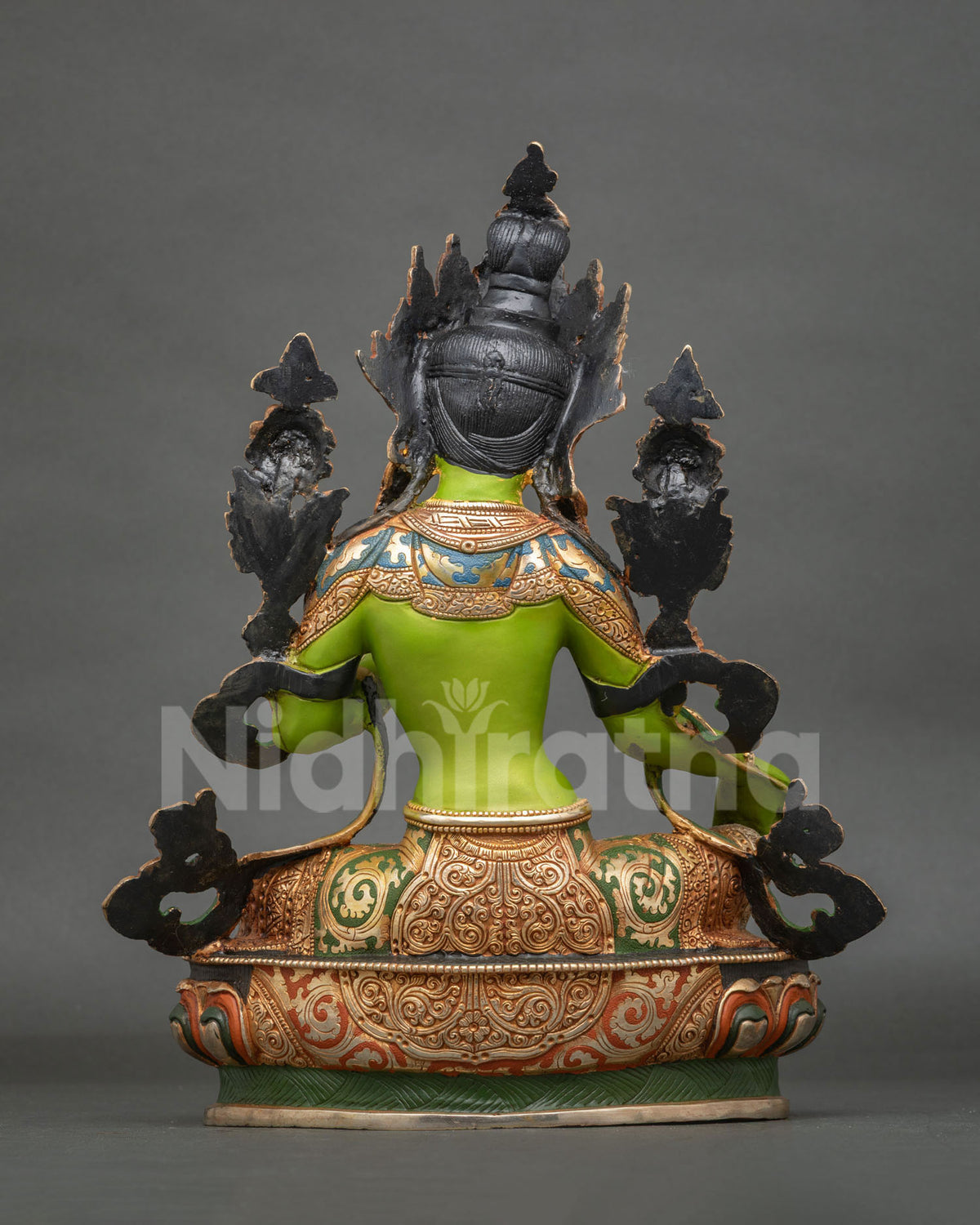 Green Tara statue displaying Varada Mudra and holding an utpala lotus.
