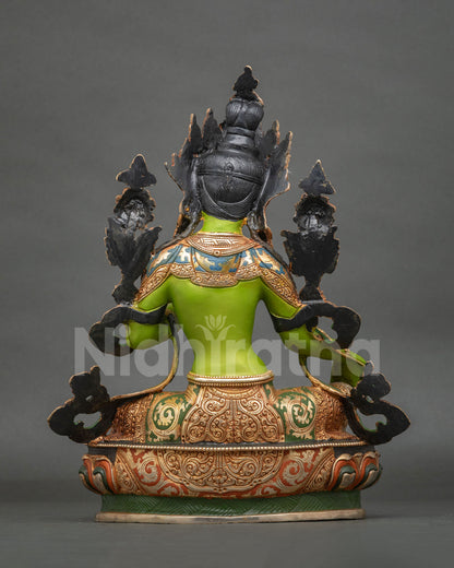 Green Tara statue displaying Varada Mudra and holding an utpala lotus.
