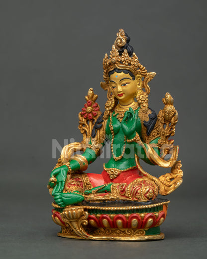 Green Tara statue with blooming utpala lotus.