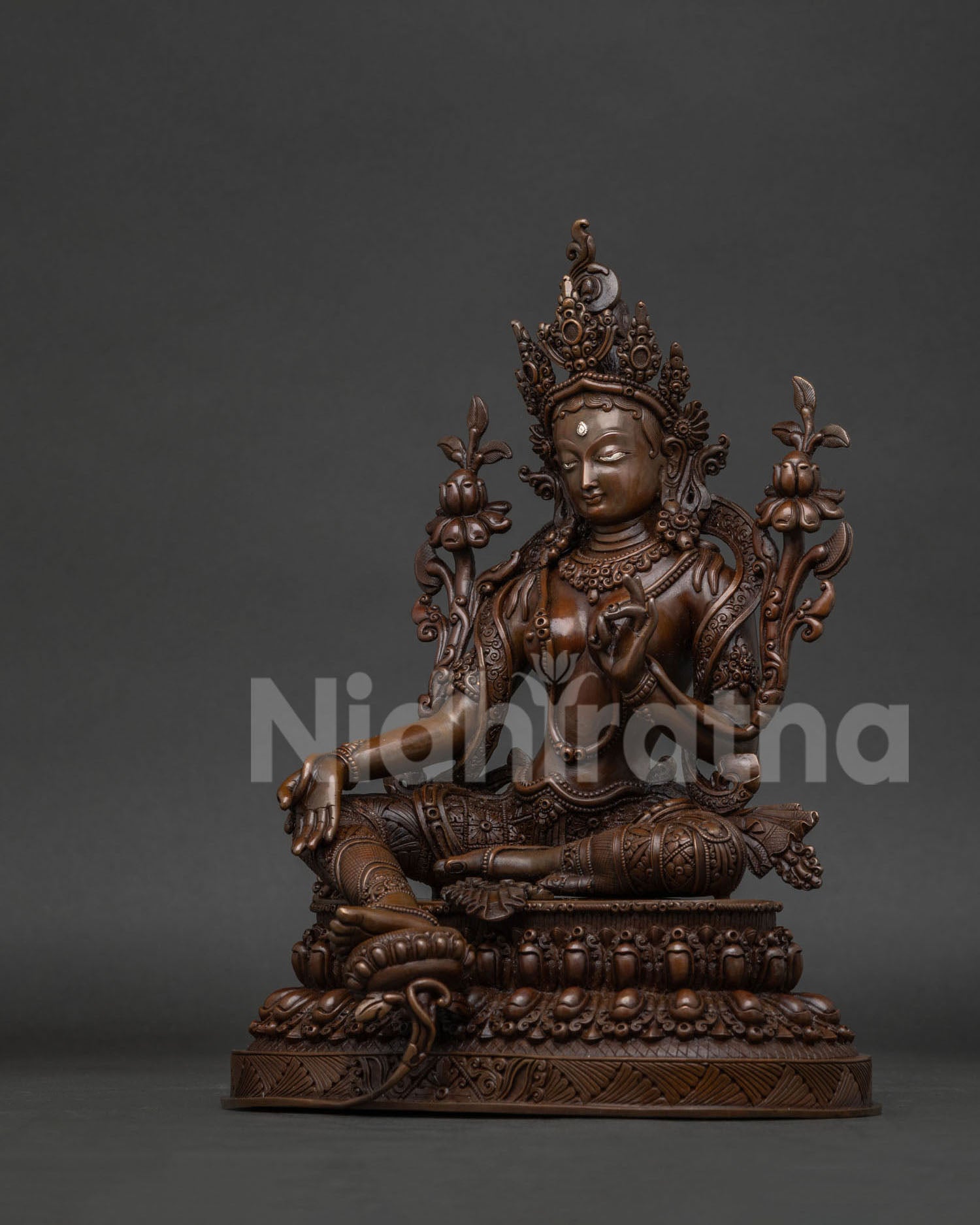 Green Tara statue with five jewel crown and floral patterned robe.