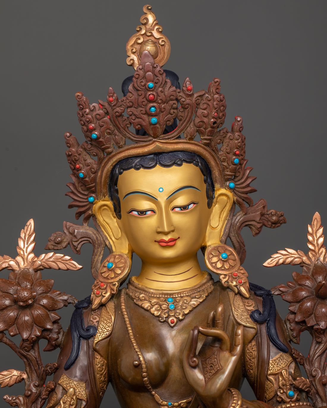 the 24 karat pure gold coated face of green tara statue