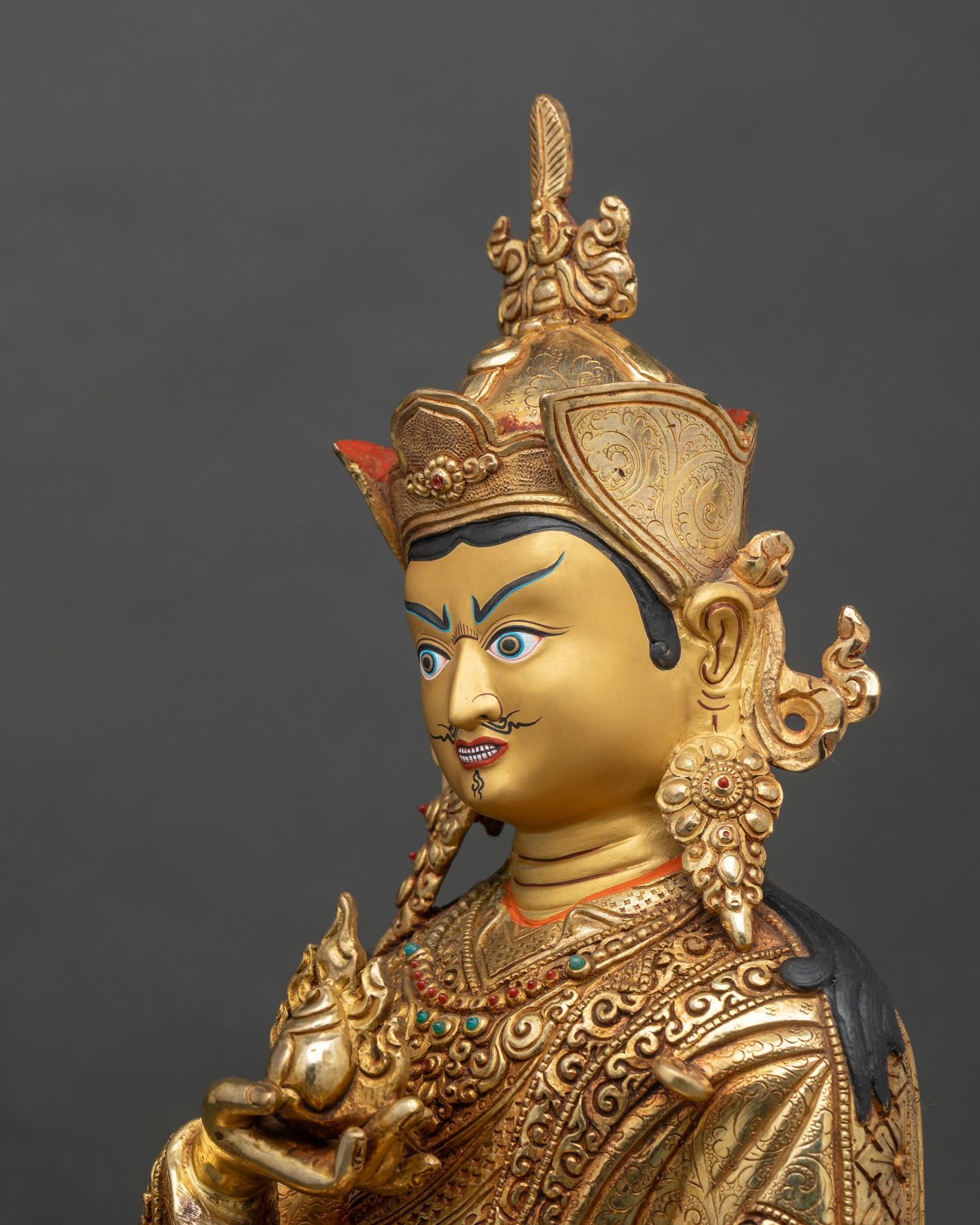 Side detail of Guru Norlha statue showing intricate robes and copper craftsmanship