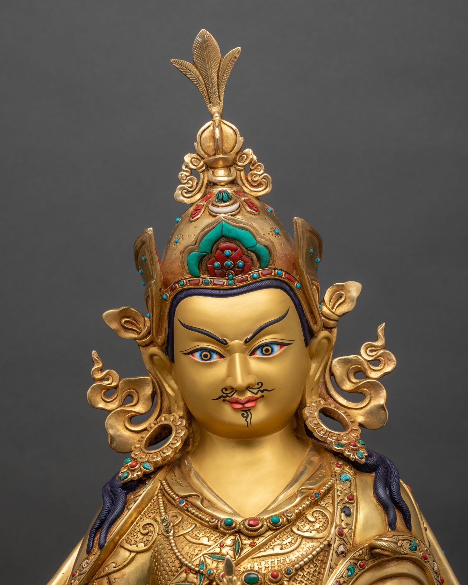 Guru Padmasambhava statue close-up showing gold fire-gilded copper and lotus details