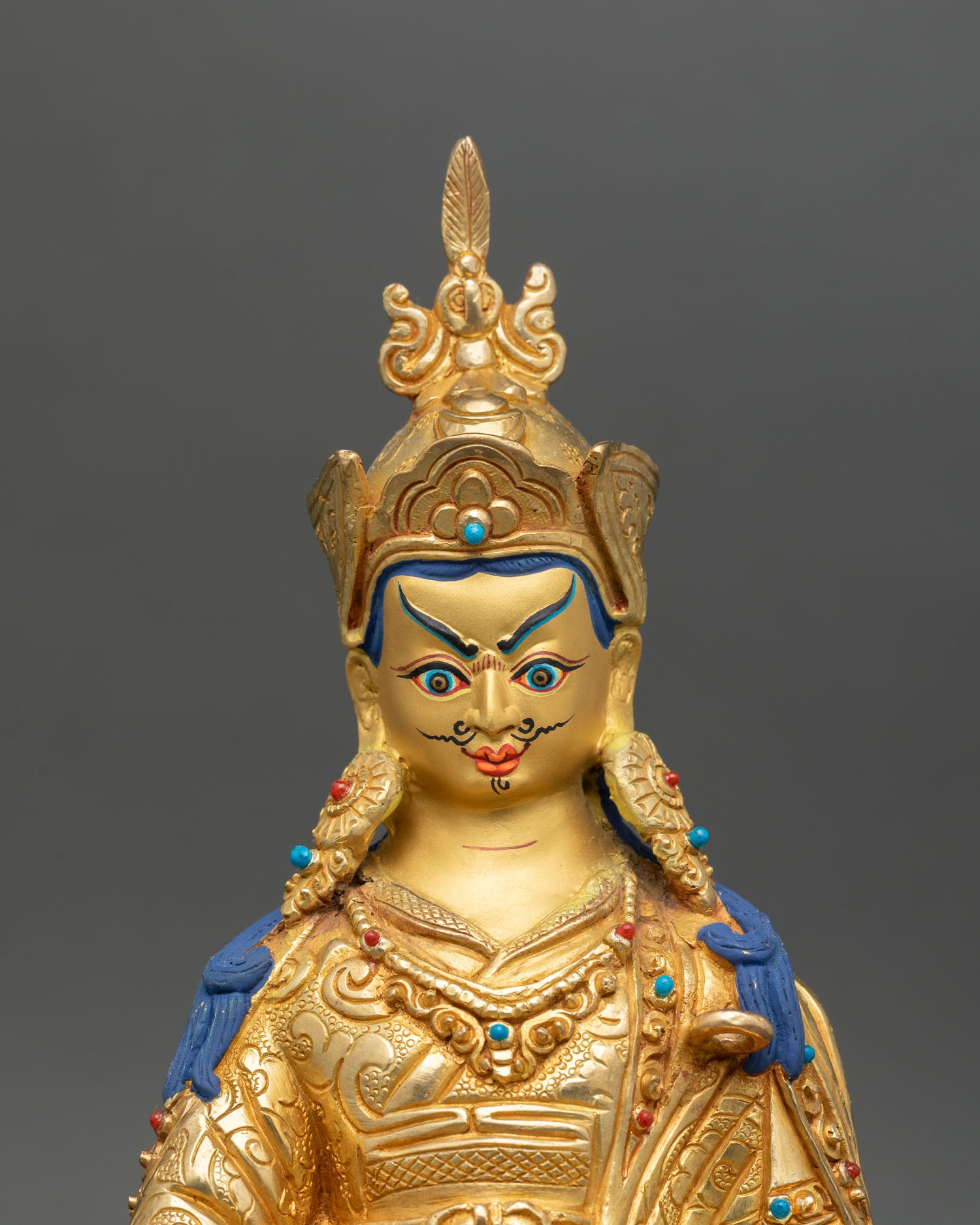 Guru Rinpoche, close-up gold-painted face detail, lost wax copper statue 