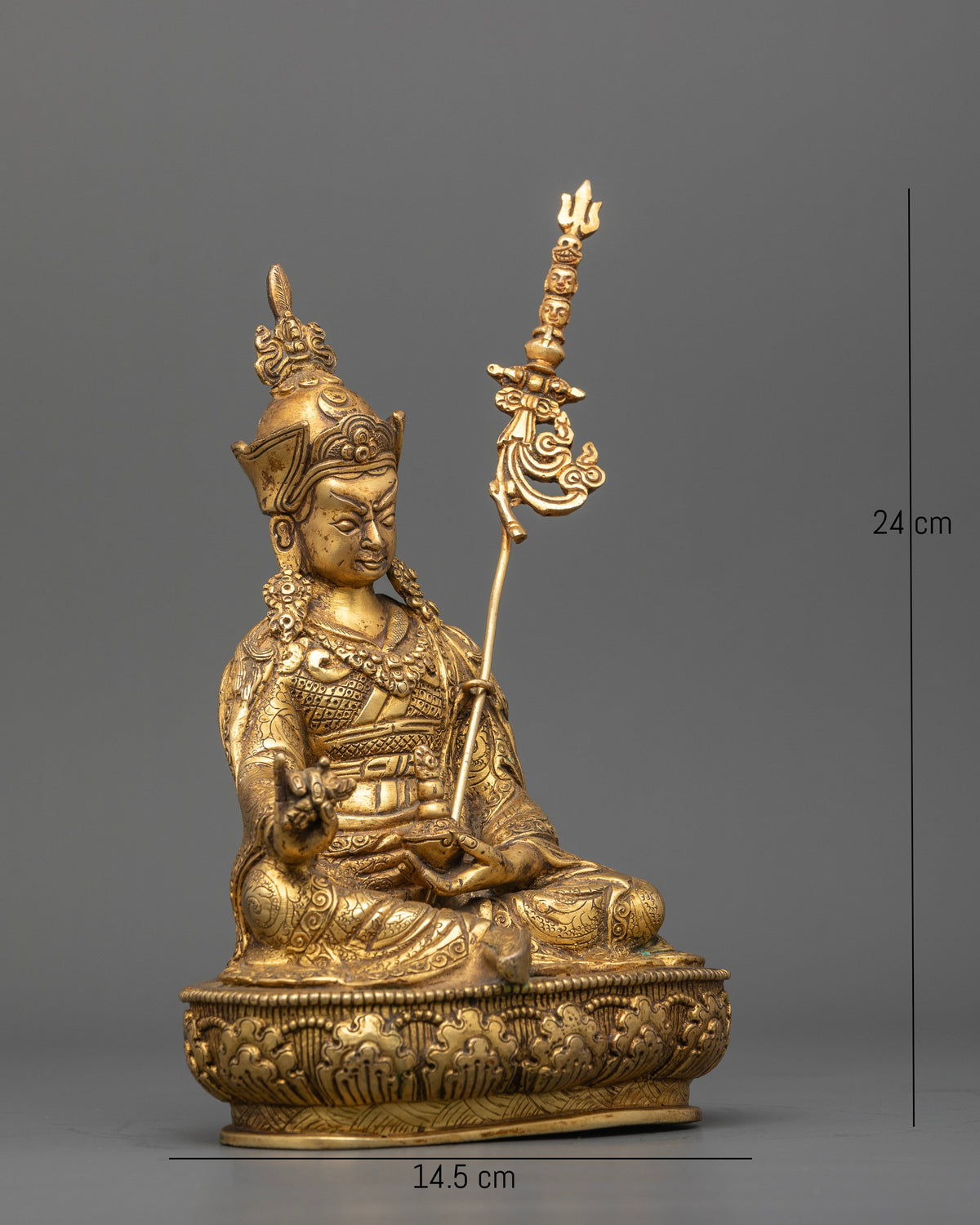 Guru Rinpoche Padmasambhava statue holding vajra and sacred skull cup.