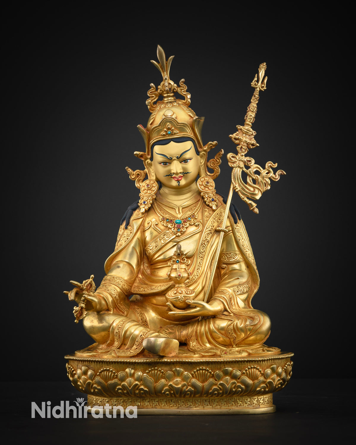 Guru Rinpoche Padmasambhava statue in gold, seated front view holding vajra and skull cup with vase