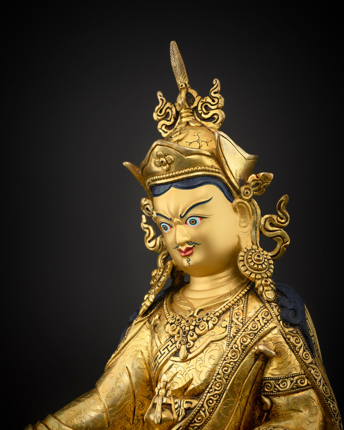 Guru Rinpoche statue 24K gold painted face close up.