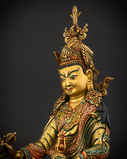 Guru Rinpoche statue wearing ceremonial robes with hand carved floral motifs and semi precious stones.