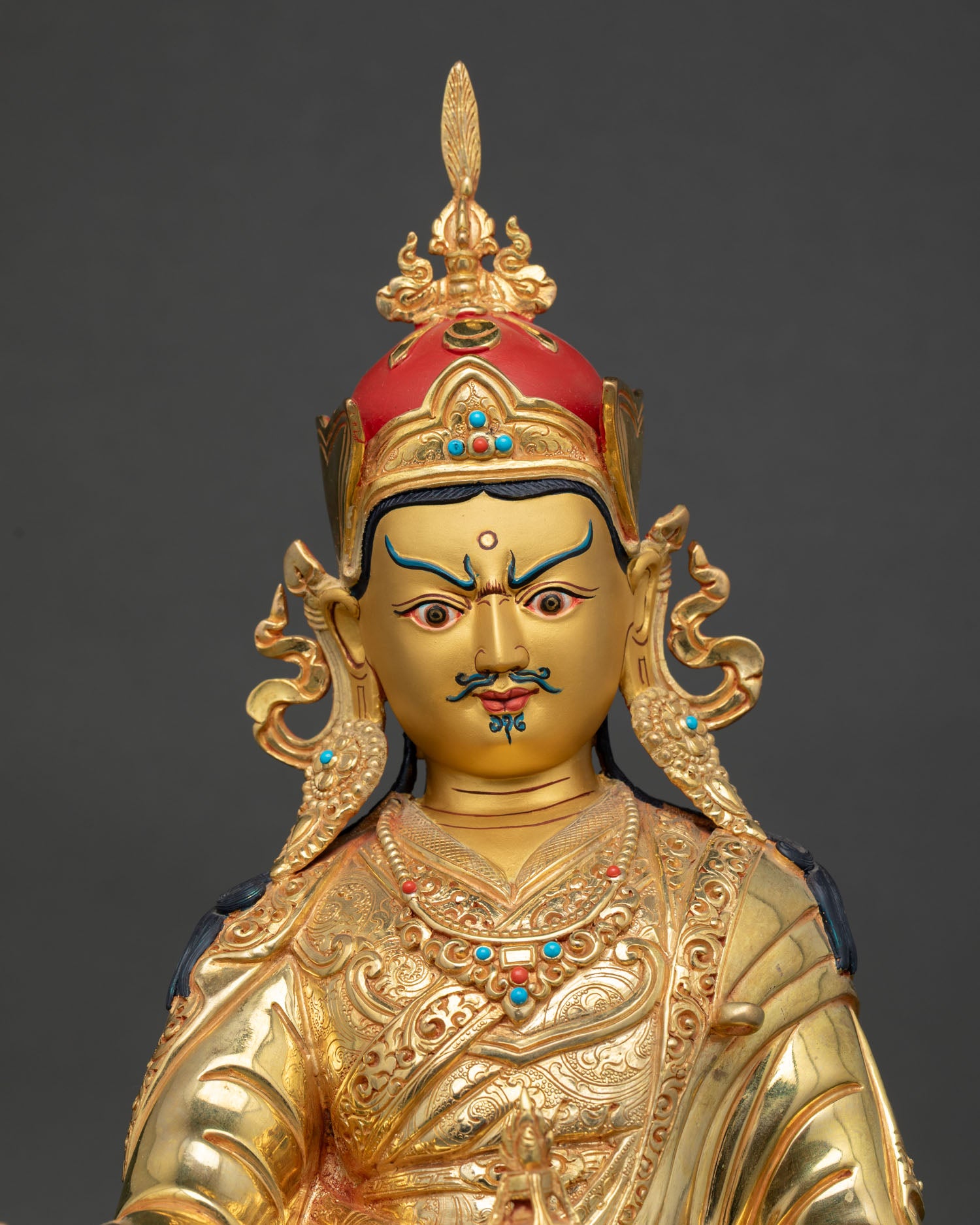 guru rinpoche statue close up, lost wax copper buddhist sculpture with gold detailing