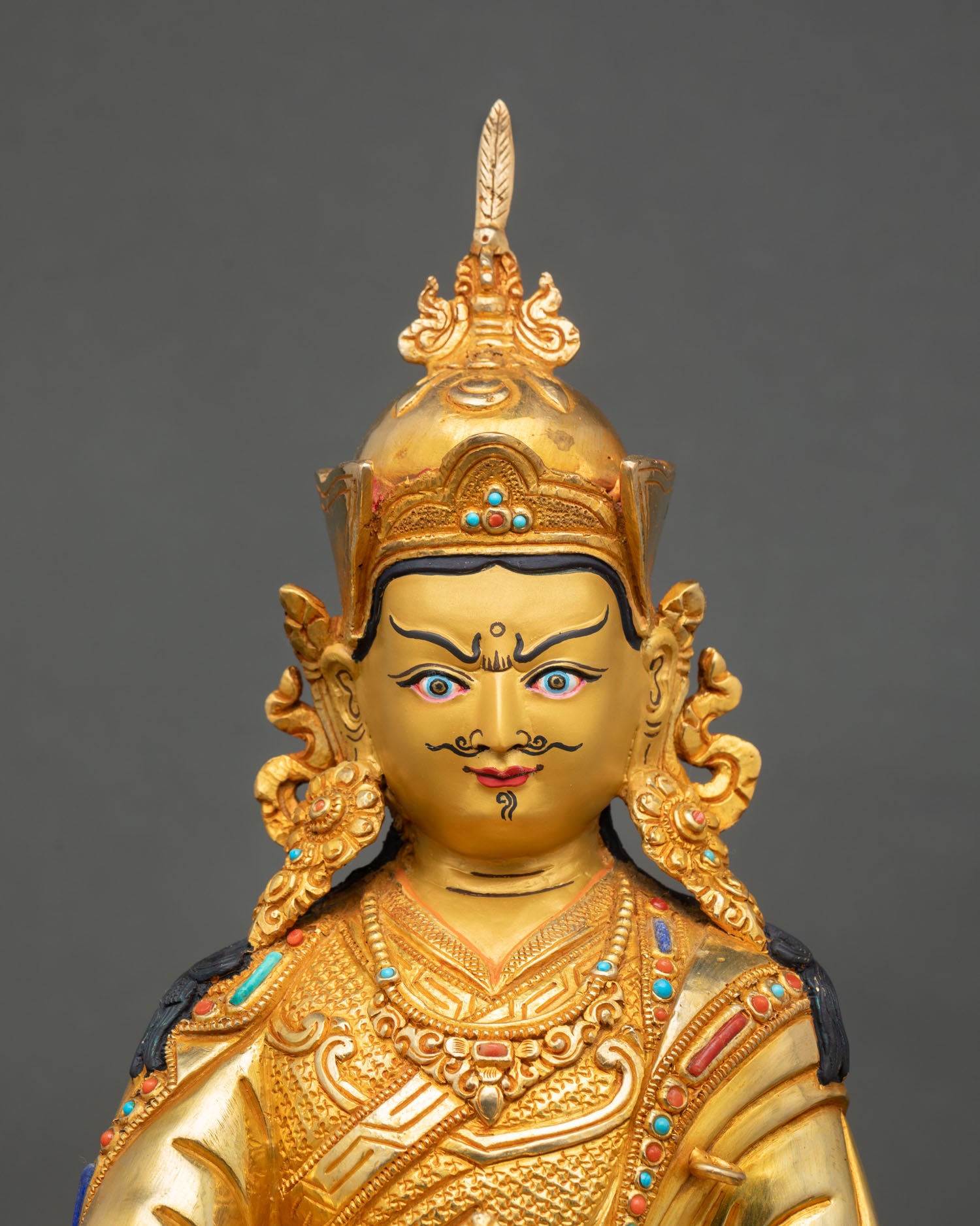 Guru Rinpoche statue close up view Padmasambhava enlightened face sacred details gold painted Himalayan Buddhist art
