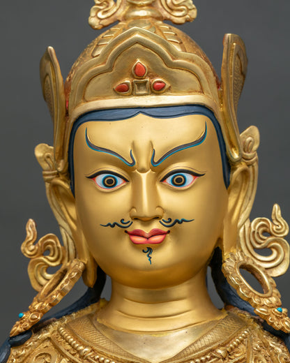 Guru Rinpoche statue face close up, gold-painted fierce expression and coral-inlaid lotus hat