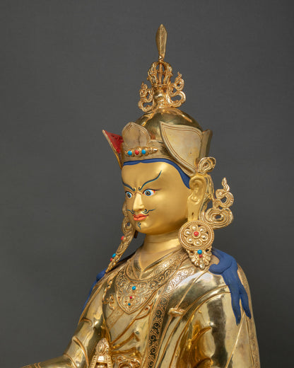 Guru Rinpoche statue profile view highlighting crown, earrings and sacred khatvanga staff ornamentation