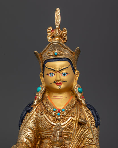 Guru Rinpoche statue wearing lotus hat holding vajra and kapala.