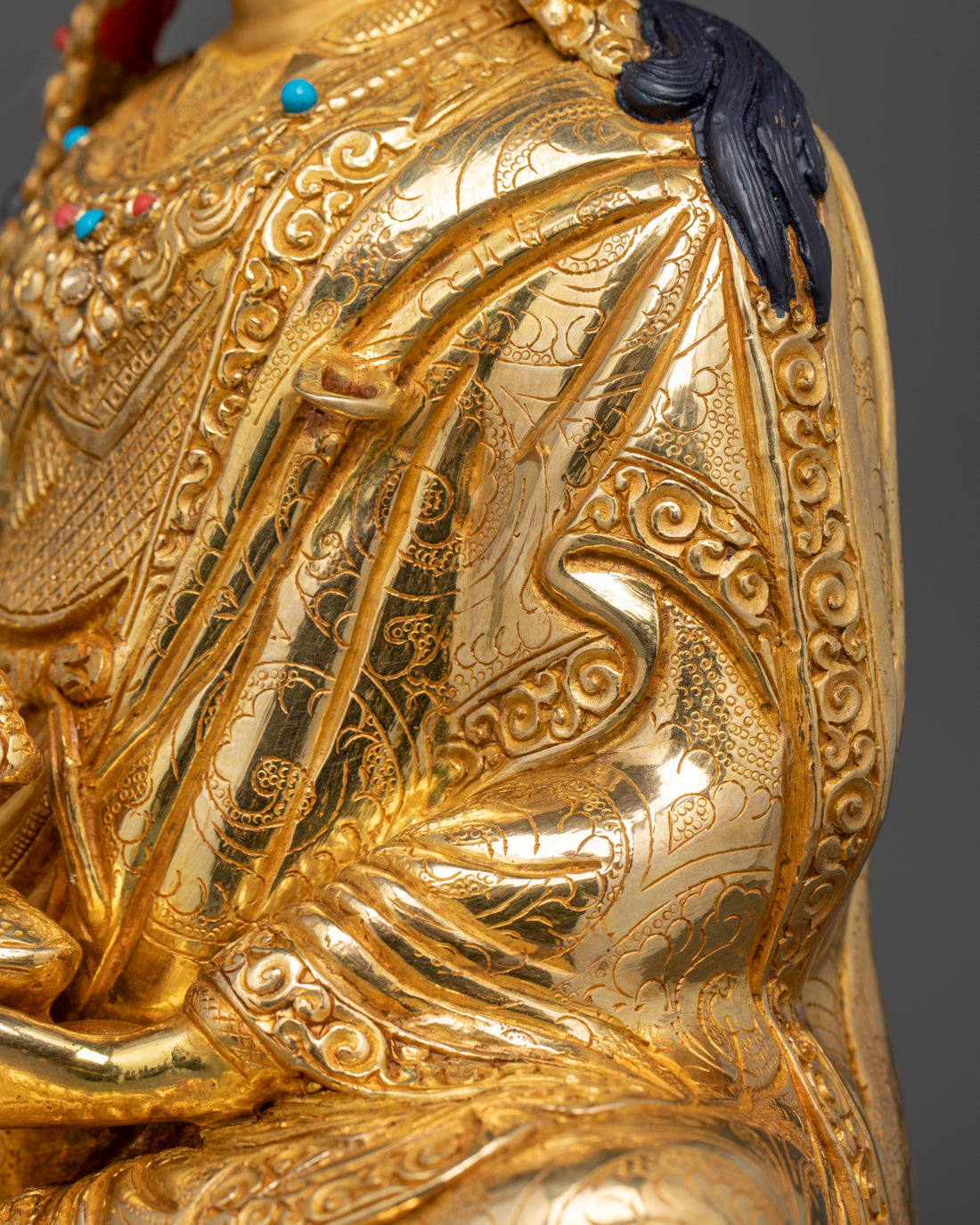 the robe being worn by guru rinpoche in the golden statue