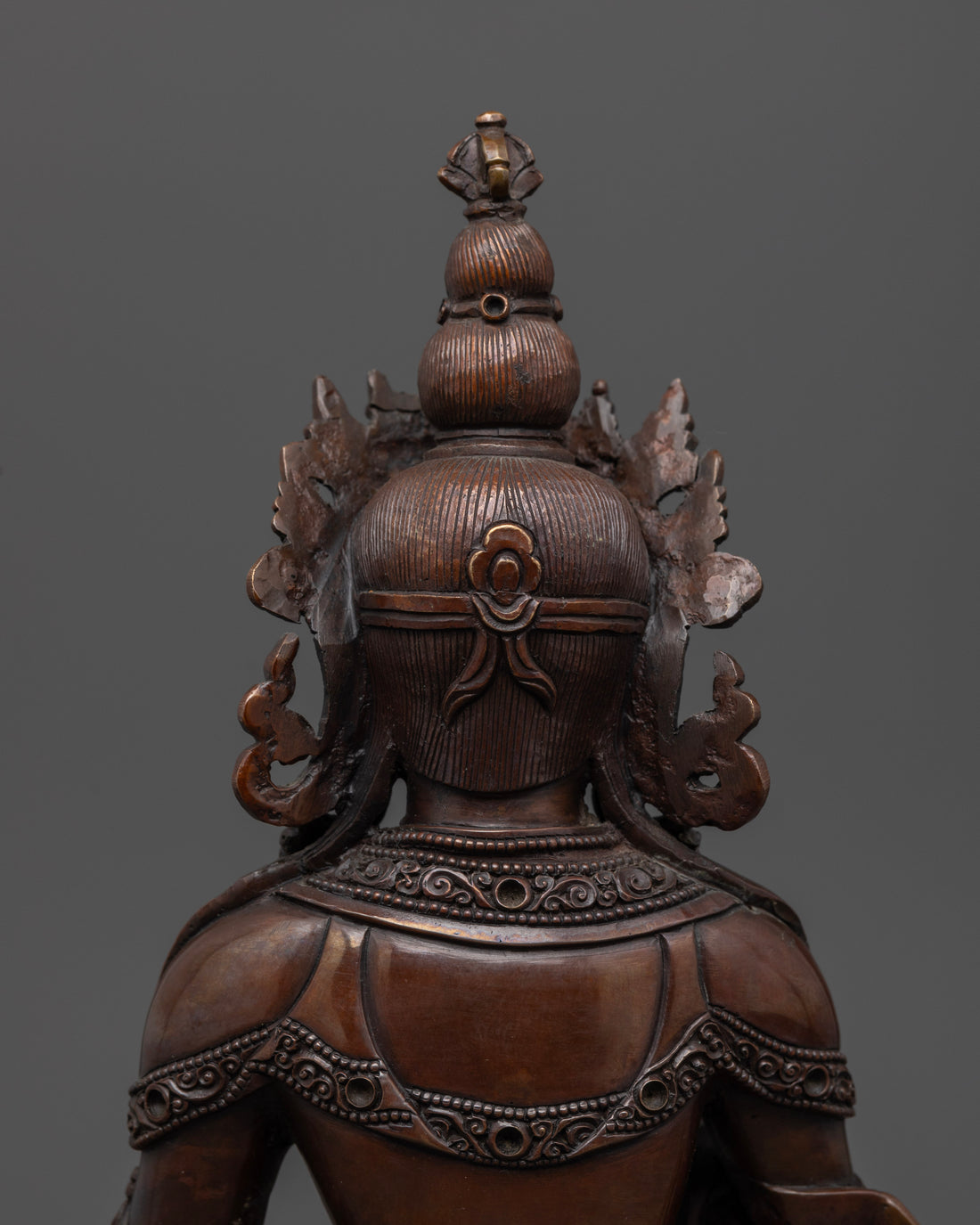 hair and crown seen from back of brown Kshitigarbha statue