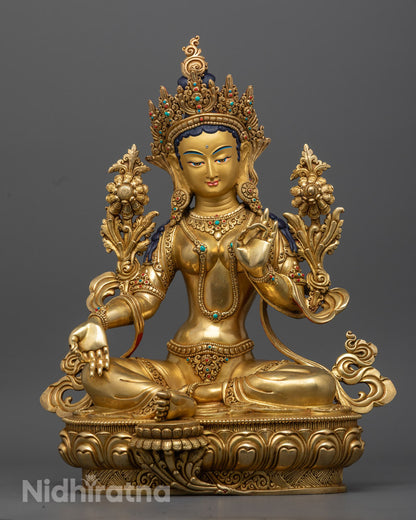 hand-carved Green Tara Statue made in Nepal, gilded in 24k gold and adorned with semi-precious stones, seated on a lotus throne.